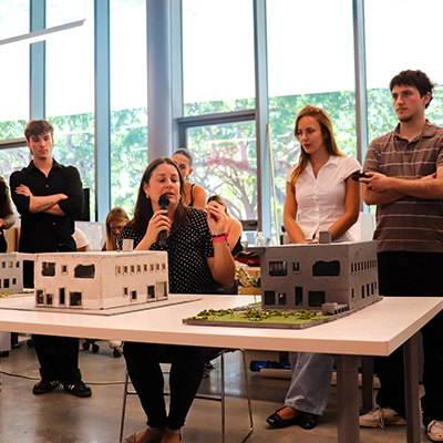 Students displaying and discussing their architecture sample homes